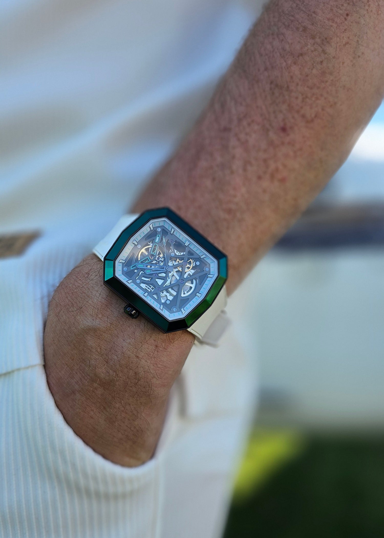 Wrist wearing a futuristic wristband with a hexagonal design on a blurred background